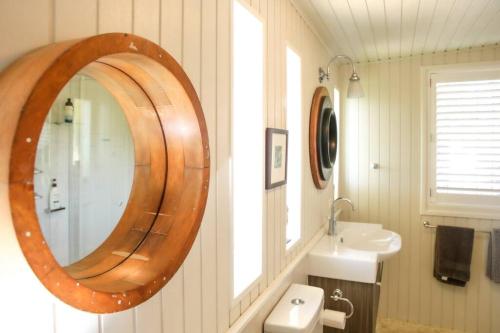 W łazience znajduje się drewniane lustro i umywalka. w obiekcie The Gables - Circa 1880 - Classic Bowral Property w mieście Bowral