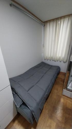 uma cama num quarto com uma janela em Choco Residence em Seul
