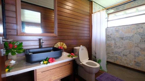 a bathroom with a sink and a toilet at Bungalow N°1 Temae Beach by Enjoy villas in Moorea