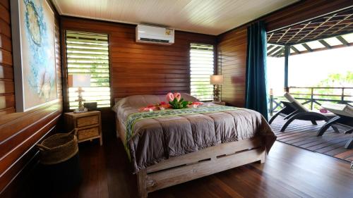 Un dormitorio con una cama con flores. en Bungalow N°1 Temae Beach by Enjoy villas, en Moorea