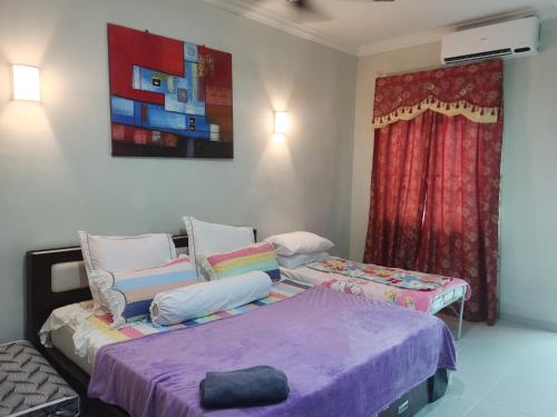 a bedroom with two beds and a window at DAlyaHomestay in Malacca
