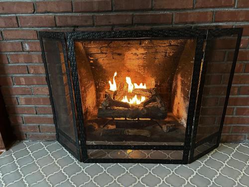 a brick fireplace with a fire in it at Historic 1905 craftsman in Centralia