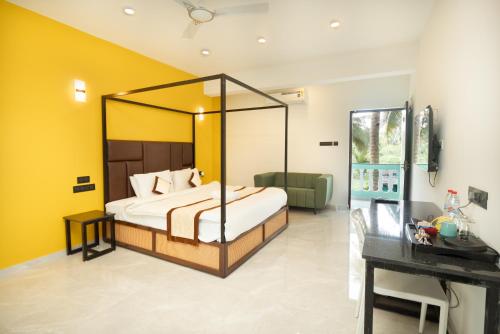 a bedroom with a canopy bed in a room with yellow walls at D7 La Serene in Benaulim
