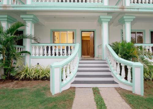 a white house with stairs leading to the front door at D7 La Serene in Benaulim