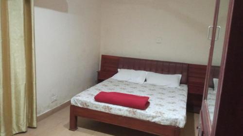 塔里约德Lake View Cottage,Wayanad的卧室里有一张床，床上铺着一条红毯子