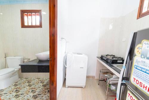 baño pequeño con fregadero y nevera en Wings Bungalow, en Phu Quoc