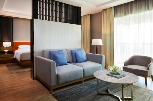a living room with a couch and a bed at Courtyard by Marriott Bandung Dago in Bandung