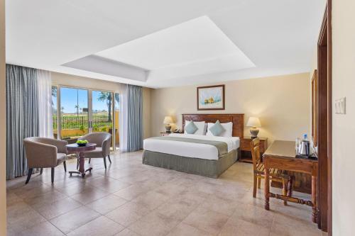 a hotel room with a bed and a desk at Al Hamra Village Hotel in Ras al Khaimah