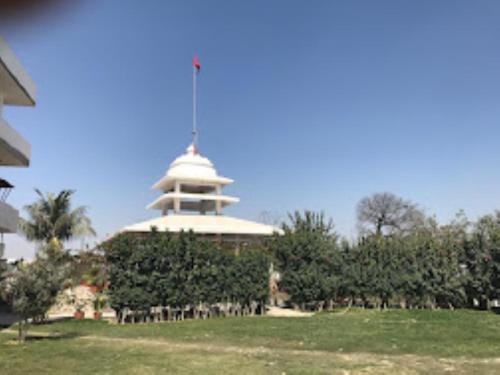 a building with a tower in the middle of a field at Vedic Villa,Varanasi in Varanasi
