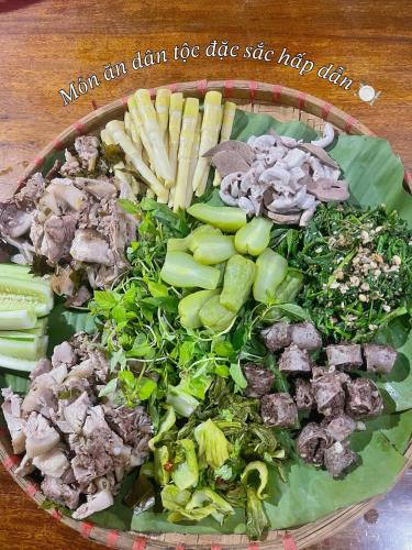 a plate of food with vegetables on a table at Homestay Cao Nguyên Mộc Châu in Mộc Châu
