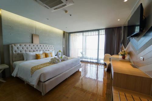 een slaapkamer met een groot wit bed en een piano bij Serene Phla Resort and Restaurant in Rayong