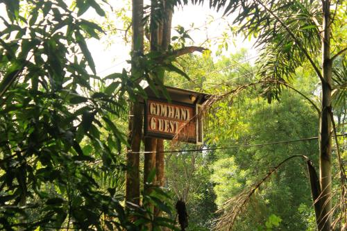 a sign in the middle of a forest with trees at Gimhani Guest House in Habarana