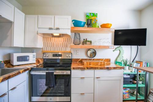 a kitchen with white cabinets and a stove top oven at Shangri-La in Folly Beach