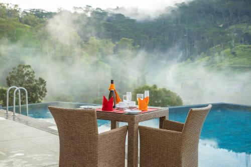 a table with a drink on it next to a pool at Skyloft Kandy by Aaradhya in Kandy
