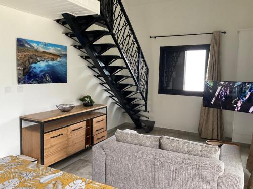 - un salon avec un escalier et un canapé dans l'établissement Les Villas de Bella, à Saint-Louis