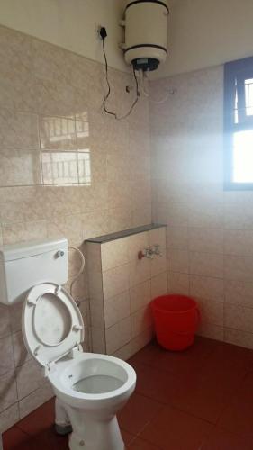 ein Bad mit einem WC mit einer Lampe darüber in der Unterkunft FLGHR Green Residency in Kodaikanal