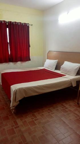 Schlafzimmer mit einem großen Bett und roten Vorhängen in der Unterkunft FLGHR Green Residency in Kodaikanal