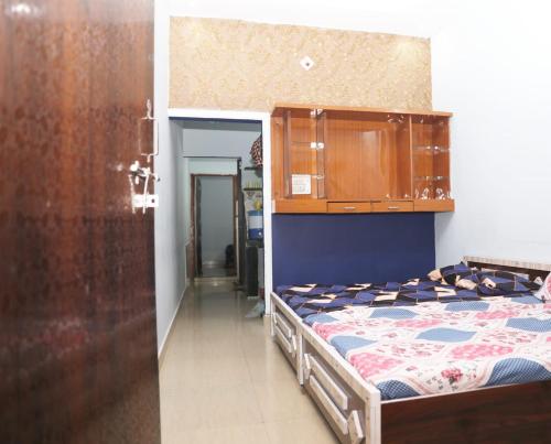 - une chambre avec un lit et une armoire en bois dans l'établissement Shree Kundkeswar Home Stay, à Ujjain