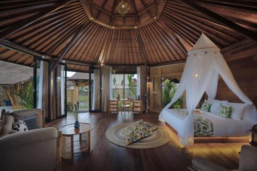 1 dormitorio con cama con dosel en una habitación en Wasita Eco Villa Ubud, en Ubud