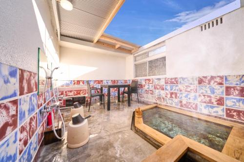 bañera de hidromasaje en una habitación con azulejos en la pared en SHAKUNAGE-BEKKAN - Vacation STAY 85762, en Yufu