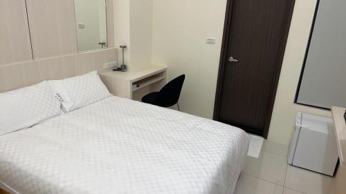 une chambre avec un lit, un bureau et un miroir dans l'établissement Mon Homestay, à Taïtung