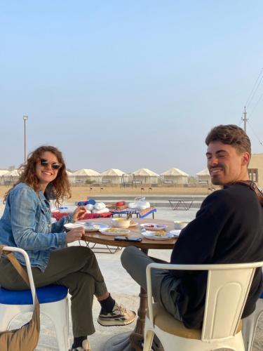 een man en een vrouw aan een tafel met eten bij Tokyo Desert Camp in Sām