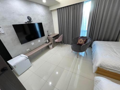 une chambre d'hôtel avec un lit et une télévision à écran plat dans l'établissement Mon Homestay, à Taïtung
