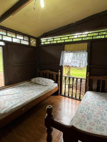 um quarto com 2 camas e uma janela em Kampung House (Minang) in Hulu Yam, Batang Kali em Batang Kali