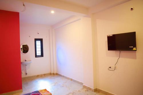 een kamer met een flatscreen-tv aan de muur bij Bhuthaa cottage stay in Auroville
