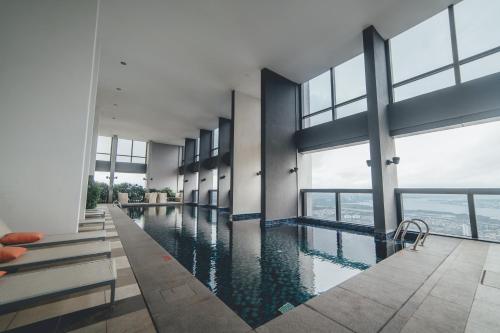 einen Pool in einem Gebäude mit Fenstern in der Unterkunft Sky88 High-rise Cozy Stay 2BR nr CIQ/KSL/Midvalley by Our Stay in Johor Bahru