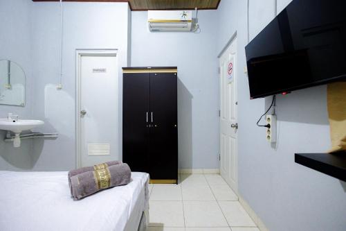 a small bathroom with a black door and a sink at Marcello Residence Siwalankerto near Petra University Surabaya Mitra RedDoorz in Surabaya