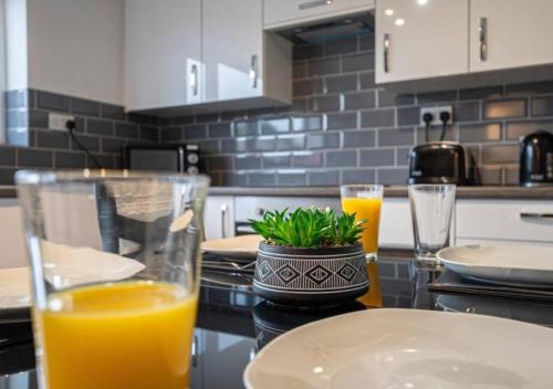 una encimera de cocina con 2 vasos de zumo de naranja en 4 Bedroom Apartment with non-smoking room, Free WiFi & Parking - Big monthly price reduction en North Hykeham