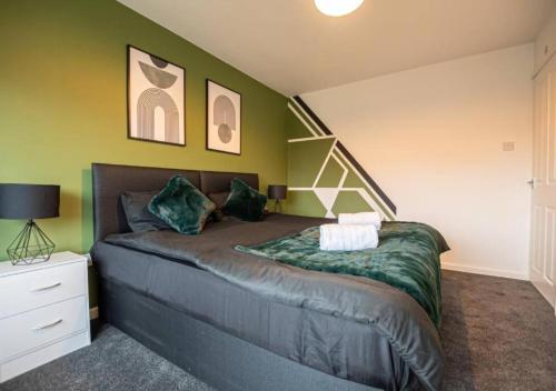 a bedroom with a bed with green walls at 4 Bedroom Apartment, easy access to all amenities - Offer long stays in North Hykeham