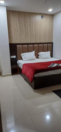 a bedroom with a large bed with a red blanket at Hotel krishna cottage in Gorakhpur