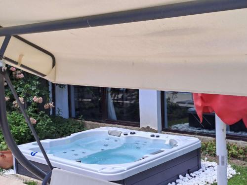 a hot tub under a canopy in a yard at Park Hotel Fairy in Chiflik