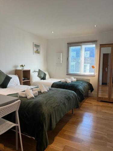 a room with three beds and a window at Private Rooms near Euston Station, Central London (123) in London