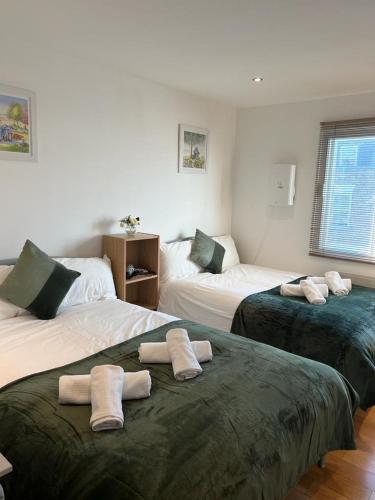 a room with two beds with towels on them at Private Rooms near Euston Station, Central London (123) in London