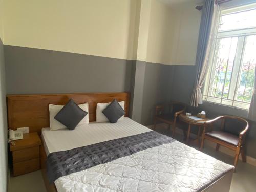 a bedroom with a bed and a chair and a window at HOTEL10H in Ho Chi Minh City