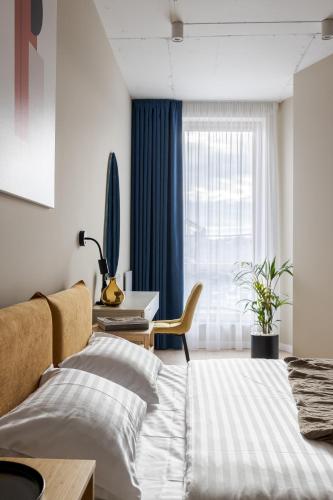 a bedroom with a bed and a desk and a window at FORUM apart in Lviv