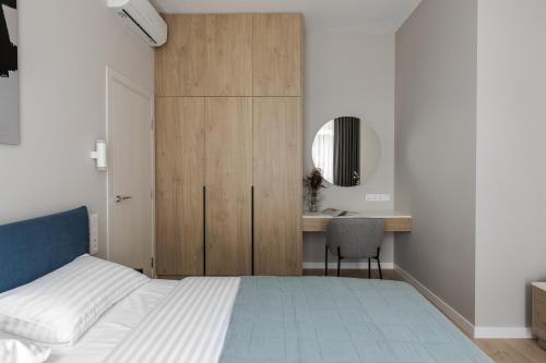a bedroom with a bed and a desk and a mirror at FORUM apart in Lviv