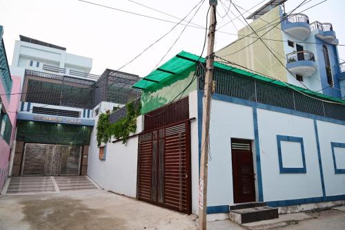 un edificio blanco y azul con dos puertas de garaje en Surendra Villa, en Ayodhya