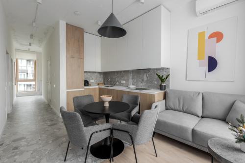a living room with a couch and a table and chairs at FORUM apart in Lviv