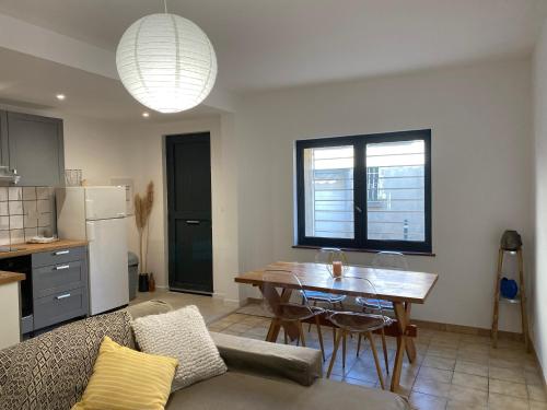 une cuisine et un salon avec une table et un canapé dans l'établissement T2 cosy avec espace extérieur, à Lézignan-Corbières