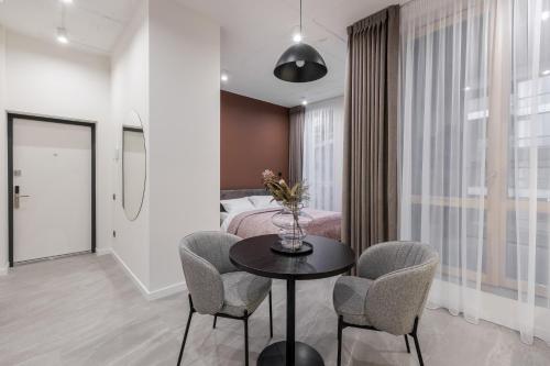 a room with a bed and a table and chairs at FORUM apart in Lviv