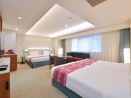 Habitación de hotel con 2 camas y escritorio en Hotel JAL City Naha, en Naha