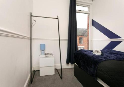 1 dormitorio con cama, espejo y ventana en 3 Bedroom Apartment - Big special offer for long stays, en Lincolnshire