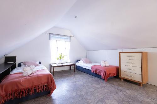 a attic bedroom with two beds and a window at Pokoje Gościnne Bartoszewo in Pilchowo