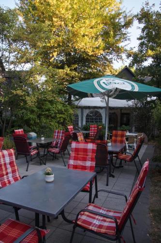 a patio with tables and chairs and an umbrella at Seminarhotel Jakobsberg in Grünberg