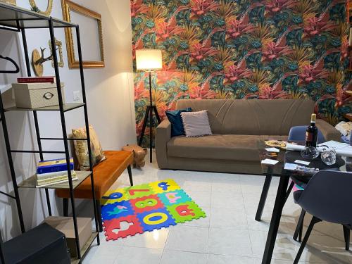 uma sala de estar com um sofá e um papel de parede floral em Nel cuore di Pescasseroli em Pescasseroli