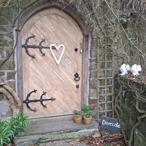 une porte en bois avec un cœur peint. dans l'établissement The Dovecote, à Launceston